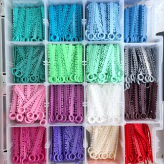 Ligaturi elastice Power Sticks Ortho Technology în mai multe culori, prezentate într-un organizator